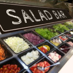 variety of fresh colorful vegetable and fruit at salad bar corner in