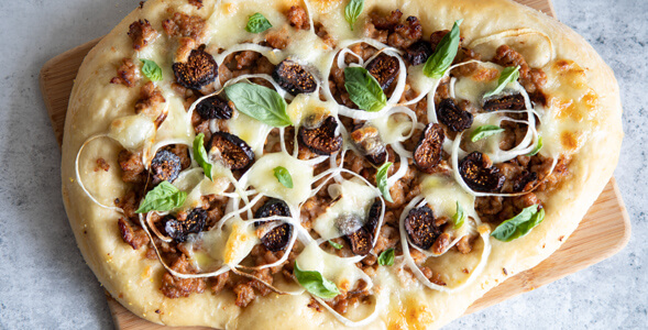 Flatbread with sausage, fig and onion on white background