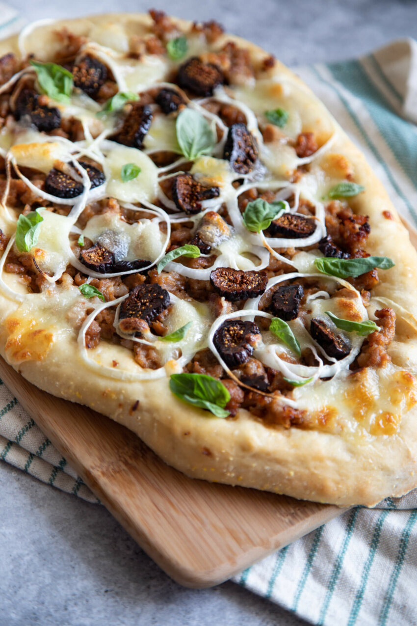 Sausage, onion, fig, flatbread on gray background